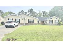 Ranch style home with black shutters, light siding and front yard with a car parked in the driveway at 1769 Crooked Pine Rd., Surfside Beach, SC 29575