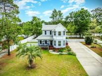 Charming two-story home with a well-manicured lawn, a driveway, a picket fence, and mature trees at 221 Lander Dr., Conway, SC 29526