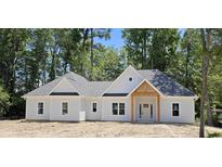 Charming, new construction, single-story home with a gray roof and a welcoming wooden-beam front entrance at 25 Pinewood Dr., Carolina Shores, SC 28467