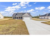 Charming single-story home featuring a two-car garage, manicured lawn, and inviting curb appeal at 2919 Hughes Gasque Rd., Aynor, SC 29511
