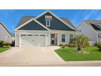 Charming single-story home with a well-manicured lawn, two-car garage, and welcoming front entrance at 3024 Calusa Dr., Little River, SC 29566
