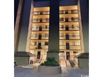 Exterior shot of condos at night featuring balconies on all floors with a landscaped entrance at 310 N 73Rd Ave. N # 5D, Myrtle Beach, SC 29572