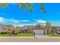 Charming brick home features a well-manicured lawn, mature trees and blue shutters, enhancing its curb appeal at 3907 Club Course Dr., North Myrtle Beach, SC 29582