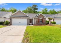 Charming single-story home featuring a brick facade, two-car garage and manicured lawn at 4165 Eva Bay Dr., Murrells Inlet, SC 29576