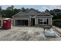 New construction features a mix of gray siding and brick accents on the exterior of the home at 56 Henderson Way, Pawleys Island, SC 29585