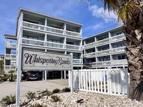 Beautiful condominium exterior featuring multiple balconies and a 'Whispering Sands' sign surrounded by well-maintained landscaping at 627 N Waccamaw Dr. # 203, Murrells Inlet, SC 29576