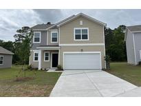 Charming two-story home with neutral siding, a two-car garage and a well-manicured lawn at 631 Muster Field Ct., Conway, SC 29526
