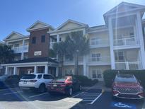 Beautiful condo building with balconies, palm trees, and convenient parking at 1000 Ray Costin Way # 114, Murrells Inlet, SC 29576