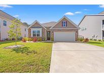 Charming home boasts a well-manicured lawn, stone accents, and a convenient two-car garage at 1087 Baker Creek Loop, Myrtle Beach, SC 29579