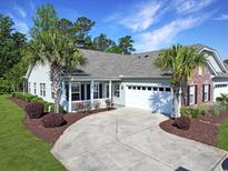Charming home features a well-manicured yard with a concrete driveway and an attached two-car garage at 1250 Camlet Ln., Little River, SC 29566