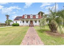Charming white two-story home with a red roof, solar panels, and a welcoming front porch at 128 Causey St., Myrtle Beach, SC 29577