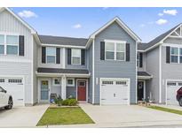 Charming townhome featuring well-maintained landscaping, a red front door, and an attached garage at 136 Villa Grande St. # B, Myrtle Beach, SC 29579