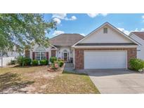 Charming single-story home with well-manicured lawn, brick accents, and attached two-car garage at 162 Jessica Lakes Dr., Conway, SC 29526