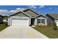 Charming single-Gathering home with a two-car garage, neat landscaping and a mix of horizontal and gabled siding at 177 Ashworth Dr., Tabor City, NC 28463
