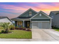 Charming single-story home featuring a manicured lawn, gray siding, a black metal roof, and an attached two-car garage at 1827 Parish Way, Myrtle Beach, SC 29577