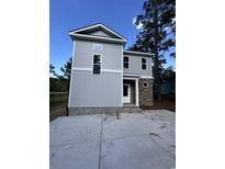 New construction home with vertical siding and stacked stone accents on the entryway column detail at 2212 Dykman Circle, Little River, SC 29566