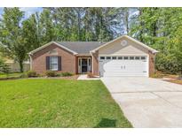 Charming brick home with a well-manicured lawn and a two-car garage at 2405 Brick Dr., Longs, SC 29568