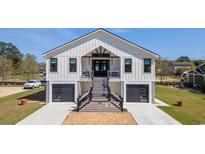 Inviting two-story modern farmhouse featuring black accents, a double garage, and an impressive elevated entryway at 28 William Screven Ln., Georgetown, SC 29440