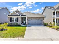 Charming single-story home with a well-manicured lawn and a convenient two-car garage at 305 Calhoun Falls Dr., Myrtle Beach, SC 29579