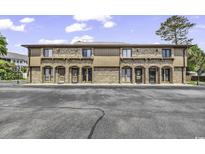 A two-story building with light brown brick and multiple entryways at 405 N Hillside Dr. N # C3, North Myrtle Beach, SC 29582