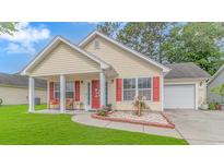 Charming single-story home with yellow siding, red shutters, a cozy front porch, and a well-manicured lawn at 409 Hunley Ln., Myrtle Beach, SC 29577
