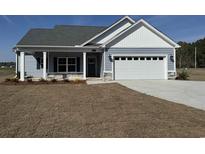 Charming single-story home featuring a two-car garage and a welcoming front porch with decorative stone accents at 4959 Dupont Rd., Aynor, SC 29511