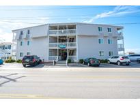 Three-story condo complex featuring gray siding, white railings, and a sign that reads 'Palm Paradise' at 5000 N Ocean Blvd. # F2, North Myrtle Beach, SC 29582