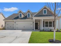 Charming home featuring a three-car garage, well-manicured lawn, and inviting entrance at 609 Carter Reid Ct., Longs, SC 29568