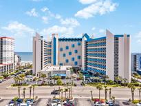 Stunning exterior of a beach-front hotel featuring a unique architectural design and a beautifully landscaped entrance at 7100 Ocean Blvd. N # 1425, Myrtle Beach, SC 29572