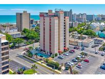 Elevated exterior view of high rise building with a pool and parking lot set against ocean and city views at 7509 N Ocean Blvd. # 101, Myrtle Beach, SC 29572