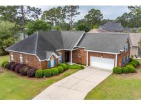 Charming brick home featuring manicured landscaping, a two-car garage, and a paved driveway at 912 Berwick Ln., Myrtle Beach, SC 29579