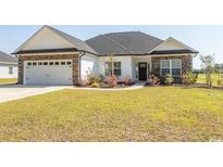 Charming single-story home featuring a manicured lawn and beautiful stone and siding exterior at Simpson Creek Dr., Loris, SC 29569