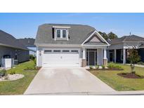 Charming single-Gathering home with a gray exterior, well-manicured lawn, and a two-car garage at 1031 Cascade Loop, Little River, SC 29566