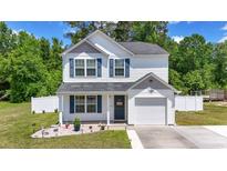 Charming two-story home features a well-manicured lawn and a classic white exterior with blue shutters at 109 Winding Path Dr., Loris, SC 29569
