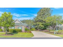 Charming brick home with lush landscaping, driveway, and an American flag on display at 139 Chenoa Dr. # D, Murrells Inlet, SC 29576