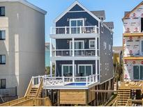 Stunning three-story home with a blue exterior, complemented by multi-level balconies with ocean views at 1611B S Ocean Blvd., Surfside Beach, SC 29575