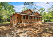 Charming single-story home featuring a welcoming front porch with wood railings and shuttered windows at 1800 9Th Ave., Conway, SC 29527