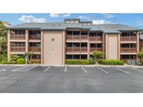 Coastal condominium building exterior with brown siding and multiple screened in patio decks and ample parking at 223 Maison Dr. # C7, Myrtle Beach, SC 29572
