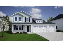 Two-story home with light-blue and grey siding, a black front door, and a three car attached garage at 269 Mayflower Dr., Calabash, NC 28467