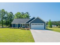 Charming single-story home with blue siding, a two-car garage, and a well-manicured lawn at 294 Field Loop Rd., Georgetown, SC 29440