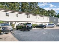 Townhouse exterior showing the front facade with ample parking and landscaping at 4616 Lomax Ct. # 9-B, Murrells Inlet, SC 29576