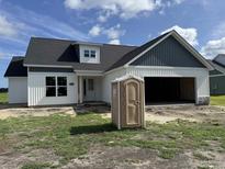Charming new construction home featuring white siding, black roof, and an attached two-car garage at 4971 Dupont Rd., Aynor, SC 29511