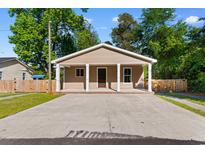 Charming single-story home features a covered porch with white pillars and a large concrete driveway at 509 S Rosemary Ave., Andrews, SC 29510