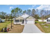 Charming single-story home with a white brick facade, green accents, and a spacious driveway at 534 War Eagle Ct., Conway, SC 29526