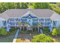 Aerial view of condo with nice balconies, palm trees, and well-maintained landscaping at 5801 Oyster Catcher Dr. # 1621, North Myrtle Beach, SC 29582