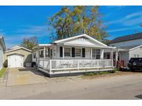 Charming white cottage with a covered porch, offering a welcoming curb appeal at 6001- 1776 S Kings Highway, Myrtle Beach, SC 29575