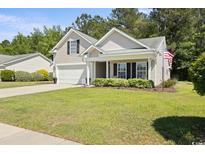 Charming home featuring a manicured lawn, classic siding, and an attached two-car garage at 680 Twinflower St., Little River, SC 29566