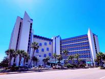 Oceanfront hotel featuring a modern design, multiple floors, and a blue and white color scheme at 7100 N Ocean Blvd. # 621, Myrtle Beach, SC 29572