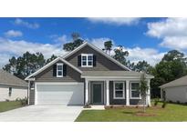 Charming one-story home boasts a two car garage, craftsman details, and a welcoming front porch at 7415 Meadow Walk Loop, Loris, SC 29569