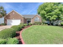 Charming brick home featuring manicured landscaping, healthy green lawn and mature trees at 78 Saltwind Loop, Murrells Inlet, SC 29576